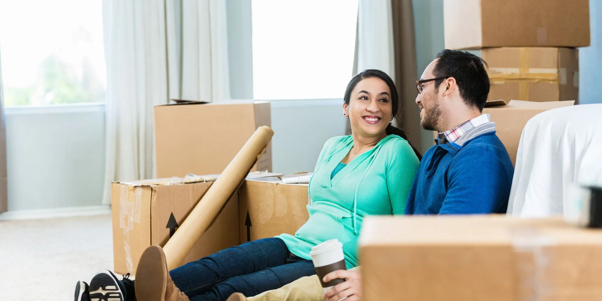 New homeowners relax in their new home surrounded by boxes.