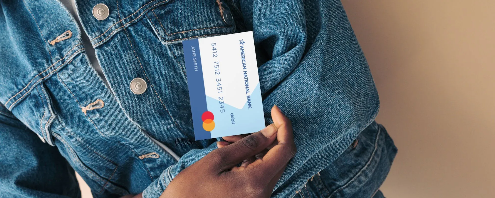 Person holding American National Bank debit card