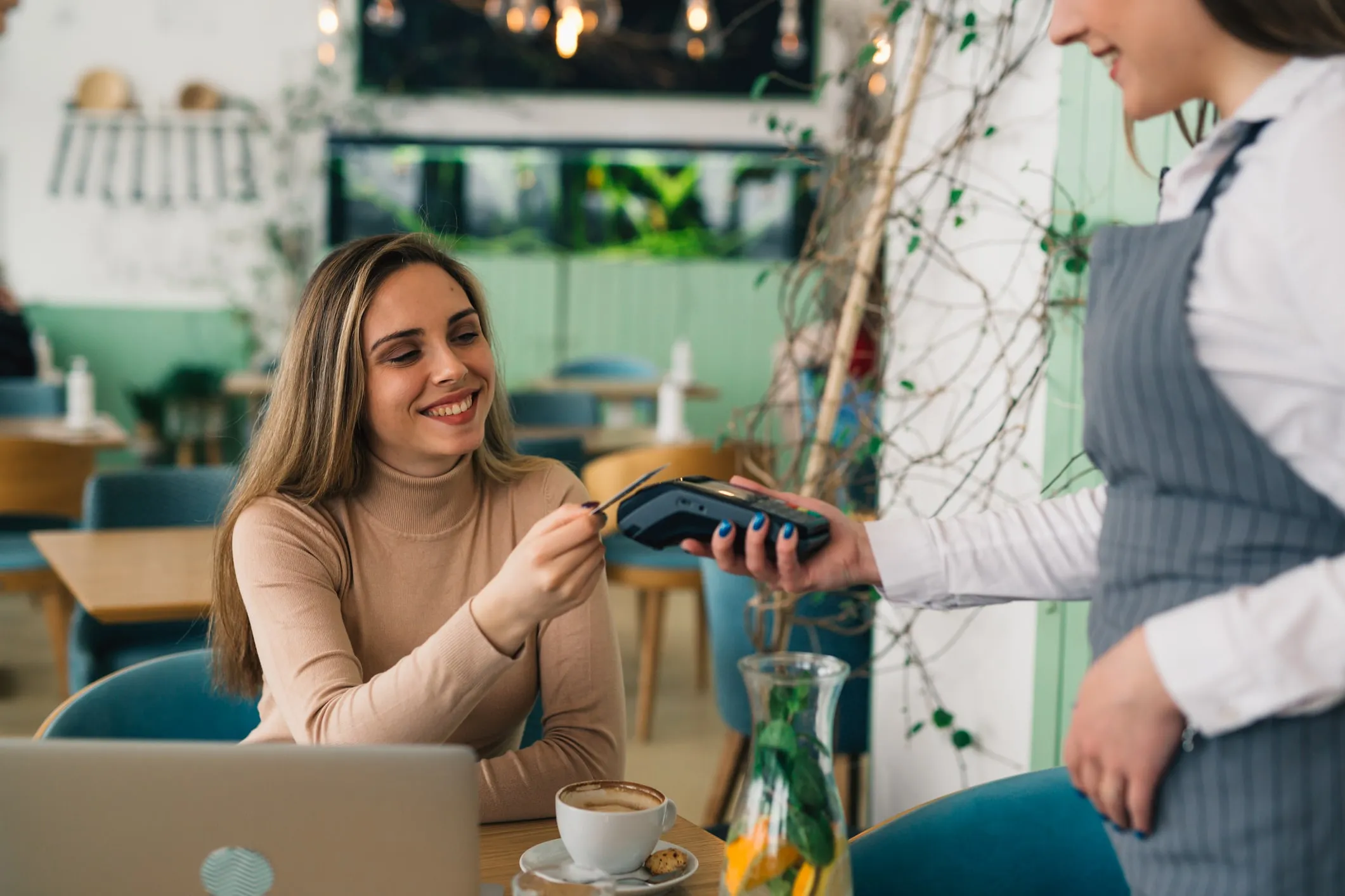 Woman paying contactless with card in restaurant