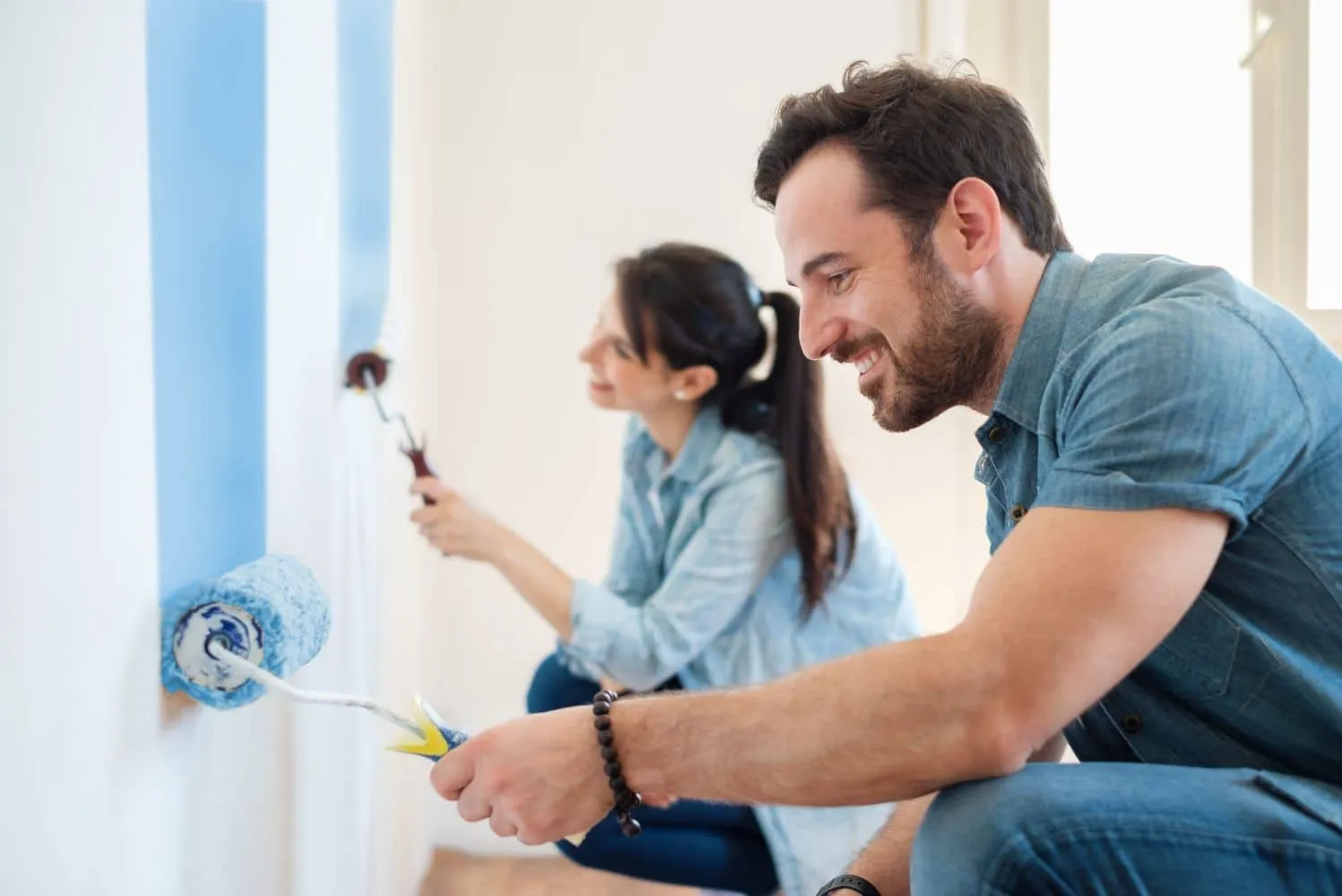 Couple painting living room walls