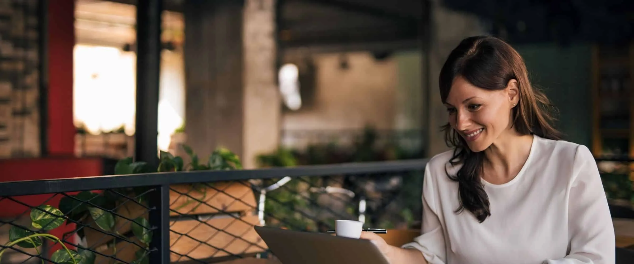 Woman working on financial budget on her laptop at coffee shop