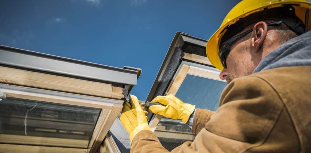 Man fixing outdoor windows on home